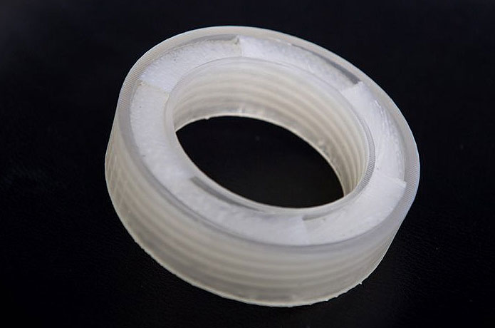 <p>The mathematically designed, 3D-printed acoustic metamaterial is shaped in such a way that it sends incoming sounds back to where they came from, Ghaffarivardavagh and Zhang say. Inside the outer ring, a helical pattern interferes with sounds, blocking them from transmitting through the open center while preserving air’s ability to flow through. Photo by Cydney Scott</p>
