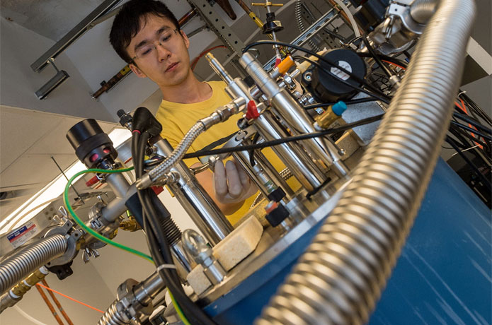 <p>Former Rice University graduate student Xinwei Li in 2016 with the terahertz spectrometer he later used to measure entanglement in the conduction electrons flowing through a 'strange metal' compound of ytterbium, rhodium and silicon. (Photo by Jeff Fitlow/Rice University)</p>
